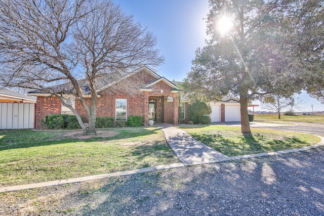 view of front of property featuring brick siding, an attached garage, driveway, and a front lawn