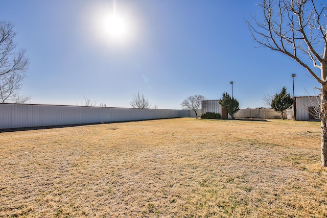 view of yard featuring an outbuilding and fence