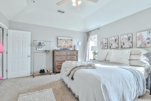 bedroom with ceiling fan, a textured ceiling, light carpet, visible vents, and vaulted ceiling