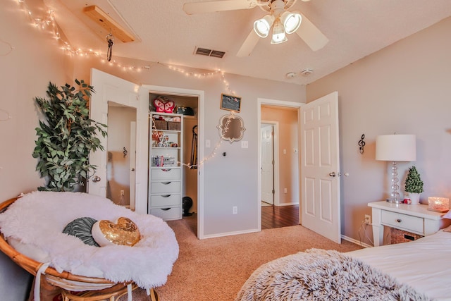 bedroom with carpet floors, visible vents, baseboards, a closet, and a walk in closet