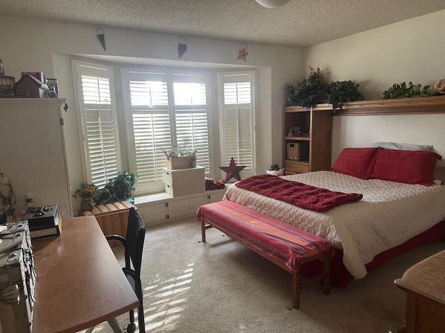 bedroom with multiple windows, a textured ceiling, and carpet