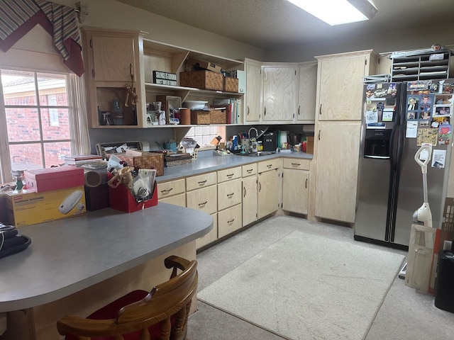 kitchen with stainless steel fridge and light brown cabinets