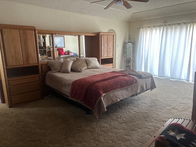 carpeted bedroom with ceiling fan and a textured ceiling