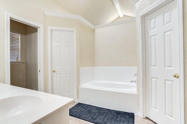 bathroom featuring hardwood / wood-style flooring, vanity, tiled bath, and vaulted ceiling