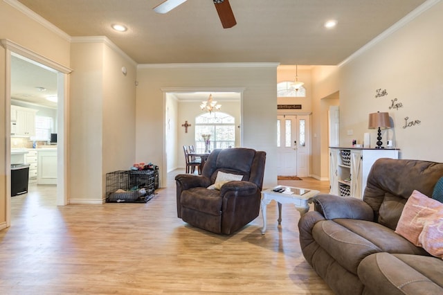 living room with crown molding, ceiling fan, and light hardwood / wood-style floors