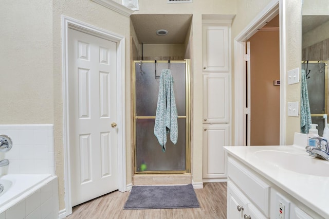 bathroom with hardwood / wood-style flooring, vanity, and shower with separate bathtub