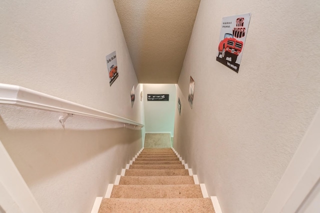 staircase featuring a textured ceiling