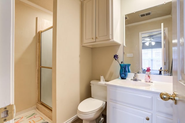 bathroom featuring ornamental molding, vanity, toilet, and a shower with shower door