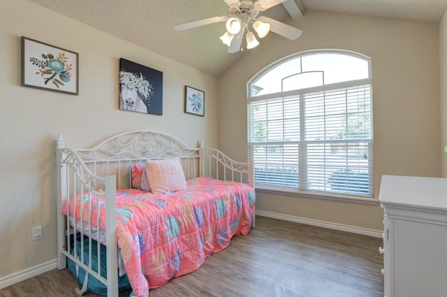 bedroom with ceiling fan, lofted ceiling, a textured ceiling, and dark hardwood / wood-style flooring