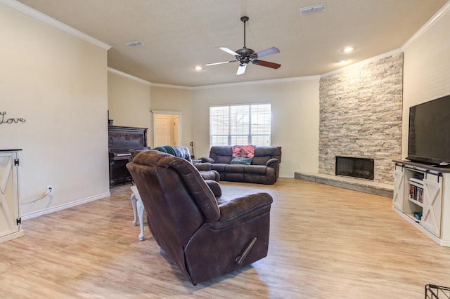 living room with crown molding, ceiling fan, a fireplace, and light hardwood / wood-style floors