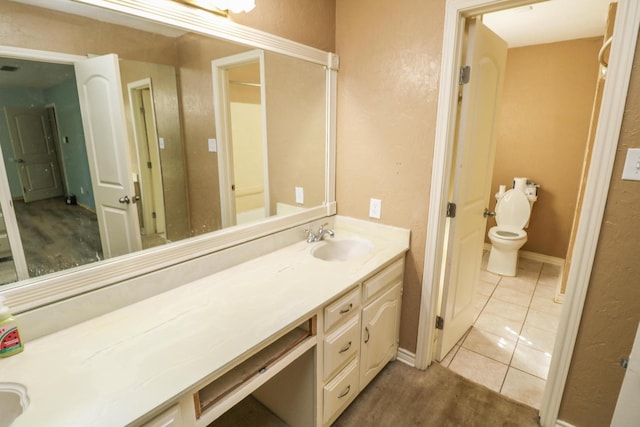 bathroom featuring vanity, tile patterned floors, and toilet