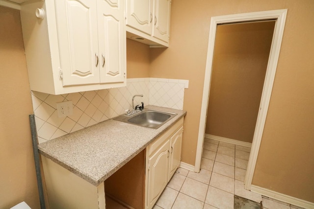 kitchen featuring white cabinetry, sink, decorative backsplash, and light tile patterned floors