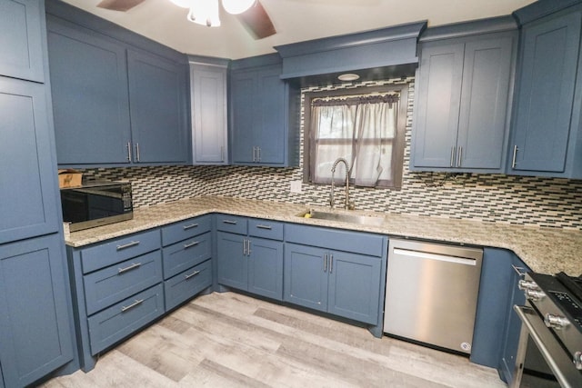 kitchen featuring stainless steel appliances, sink, decorative backsplash, and light hardwood / wood-style flooring