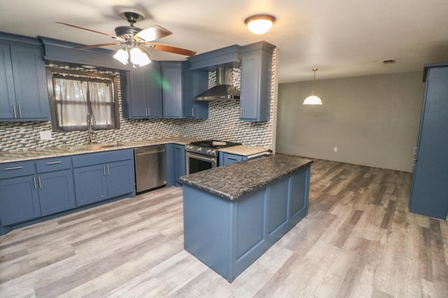 kitchen featuring appliances with stainless steel finishes, hanging light fixtures, blue cabinets, kitchen peninsula, and wall chimney exhaust hood