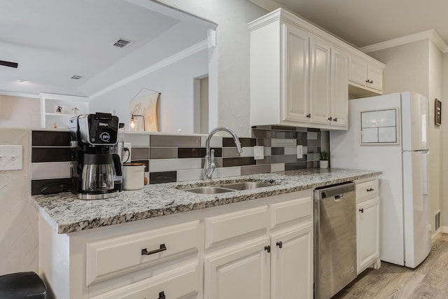 kitchen featuring ornamental molding, dishwasher, light wood finished floors, a sink, and visible vents