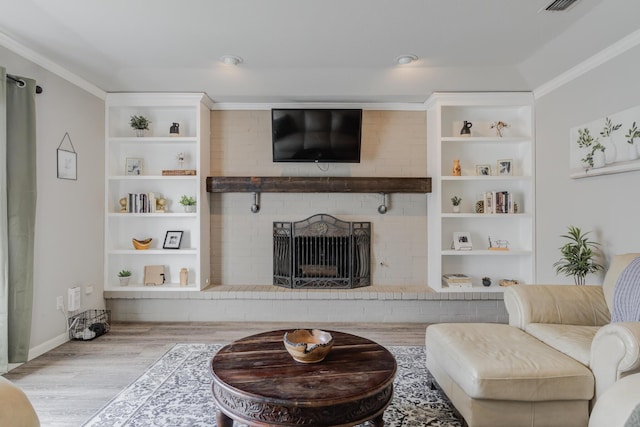 living room with ornamental molding, wood finished floors, and a fireplace