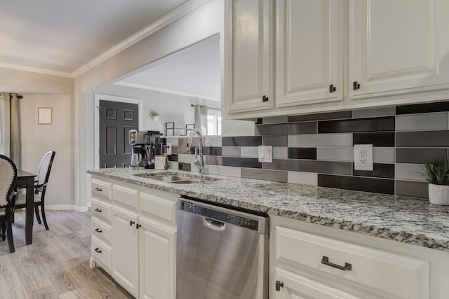 kitchen featuring stainless steel dishwasher, white cabinets, backsplash, a sink, and light wood-type flooring