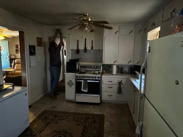 kitchen featuring ceiling fan, white appliances, tasteful backsplash, and white cabinets