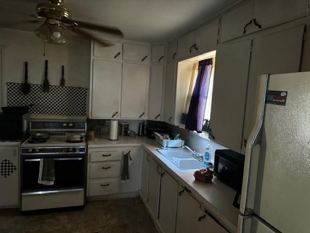 kitchen with sink, white appliances, ceiling fan, white cabinetry, and decorative backsplash