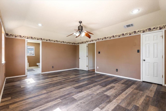 spare room with dark wood-type flooring, ceiling fan, lofted ceiling, and a textured ceiling