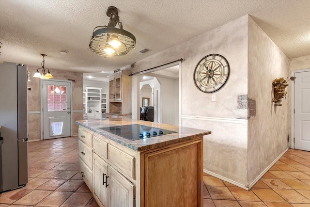 kitchen featuring stainless steel refrigerator, hanging light fixtures, black electric stovetop, a textured ceiling, and a kitchen island