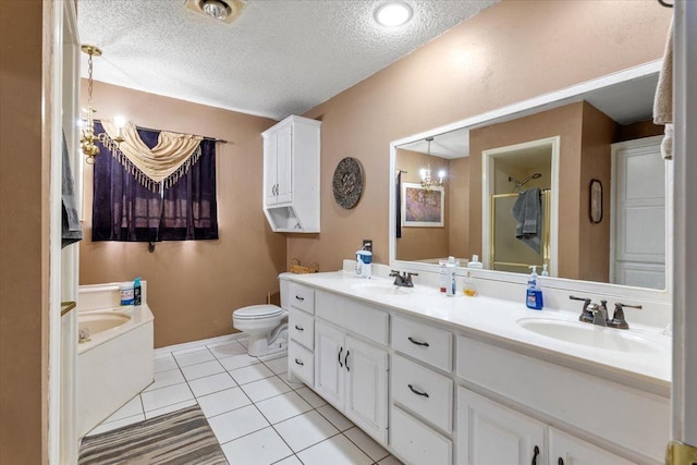 bathroom with tile patterned floors, toilet, a textured ceiling, vanity, and a notable chandelier