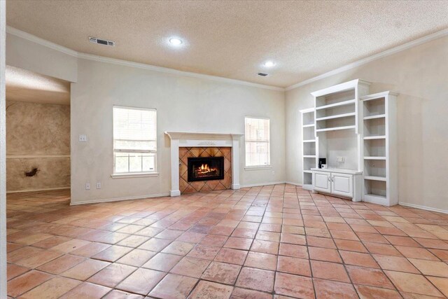 unfurnished living room with light tile patterned floors, crown molding, a tile fireplace, and a textured ceiling