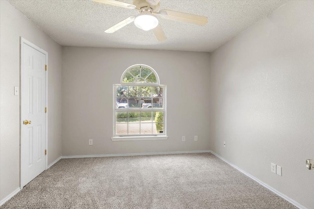 unfurnished room with ceiling fan, carpet flooring, and a textured ceiling