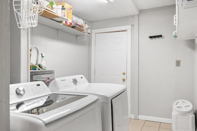 laundry room with light tile patterned floors, a textured ceiling, and independent washer and dryer