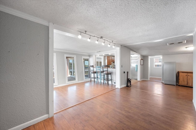 unfurnished living room featuring wood-type flooring and a textured ceiling