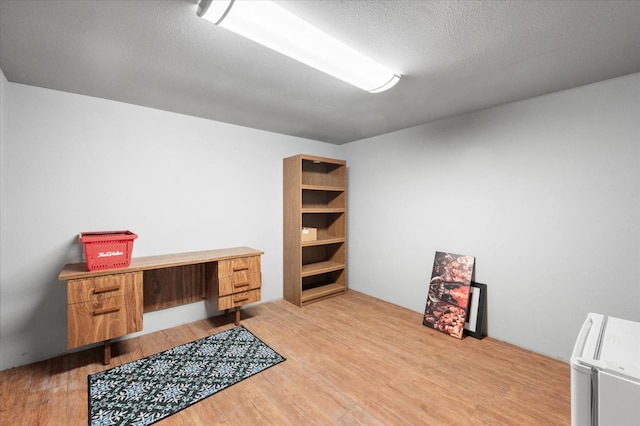 home office featuring a textured ceiling and light wood-type flooring