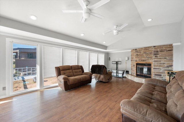 living room featuring hardwood / wood-style flooring, ceiling fan, lofted ceiling, and a fireplace