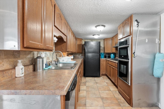 kitchen with light tile patterned flooring, sink, a textured ceiling, appliances with stainless steel finishes, and decorative backsplash