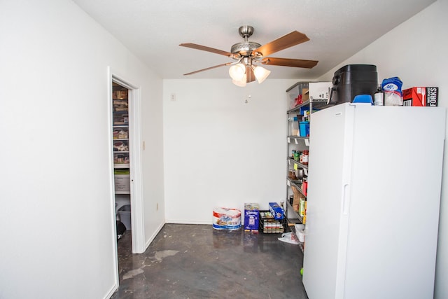 garage with baseboards, freestanding refrigerator, and a ceiling fan