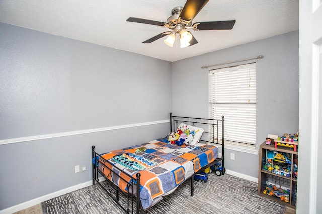 bedroom featuring a ceiling fan, baseboards, and multiple windows