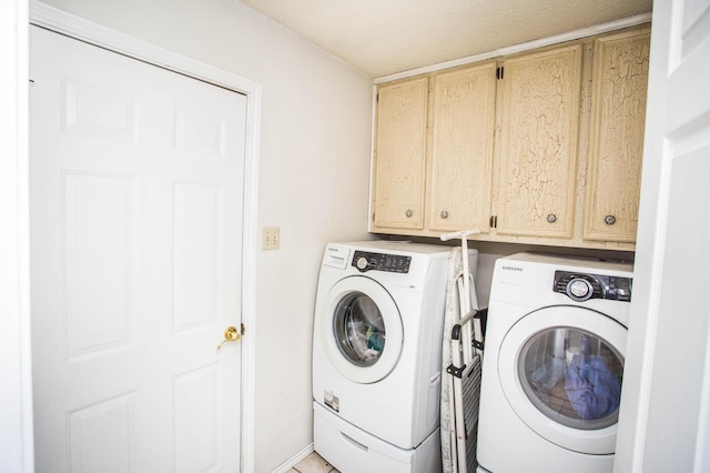 laundry area with washing machine and dryer, a textured ceiling, and cabinet space