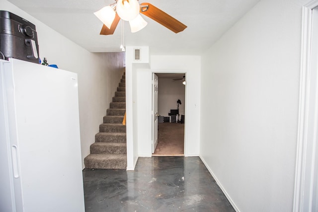 staircase featuring finished concrete floors, visible vents, baseboards, and a ceiling fan