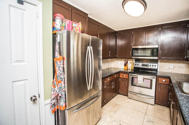 kitchen featuring dark stone counters, dark brown cabinets, backsplash, and stainless steel appliances