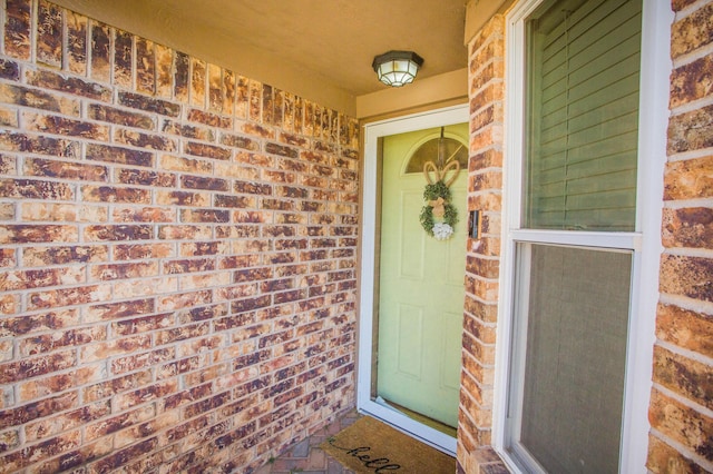 entrance to property featuring brick siding