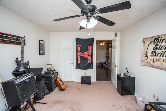 office area with a textured ceiling, a ceiling fan, visible vents, and carpet floors