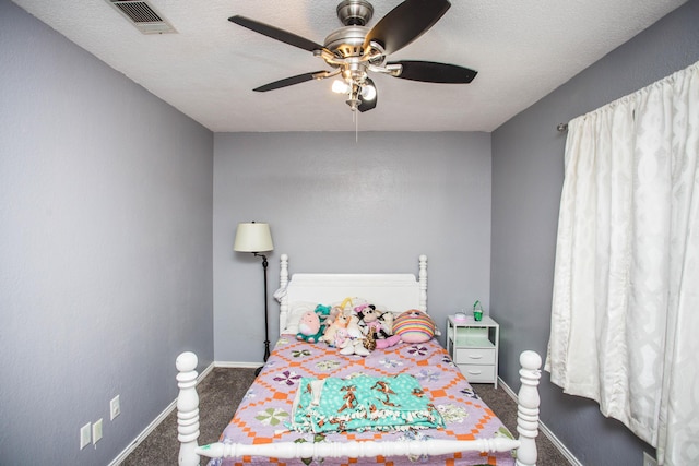 bedroom featuring visible vents, baseboards, a ceiling fan, carpet, and a textured ceiling