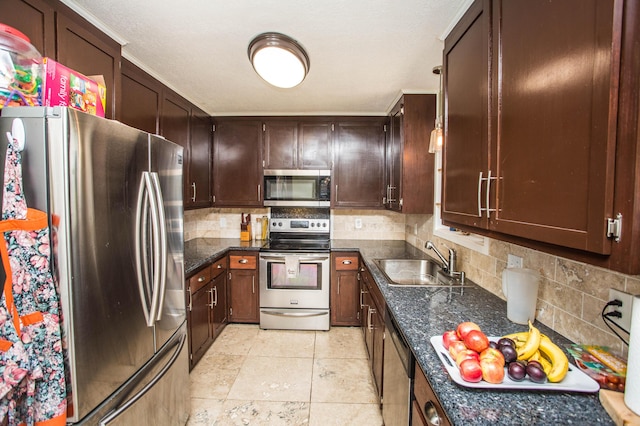 kitchen with tasteful backsplash, a sink, dark brown cabinets, and appliances with stainless steel finishes