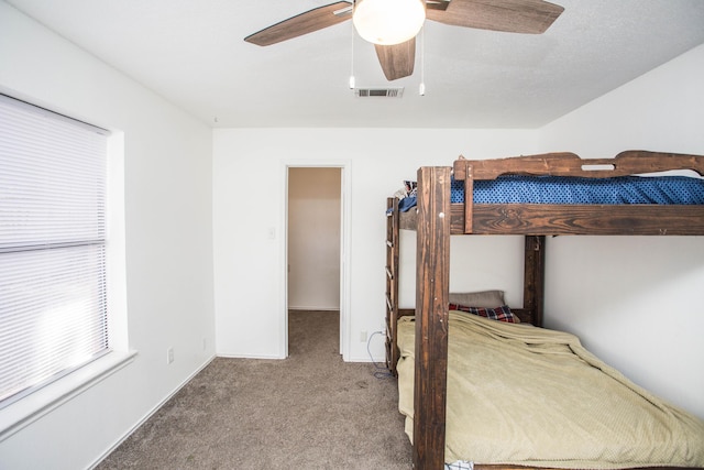 unfurnished bedroom with carpet flooring, visible vents, baseboards, and a ceiling fan