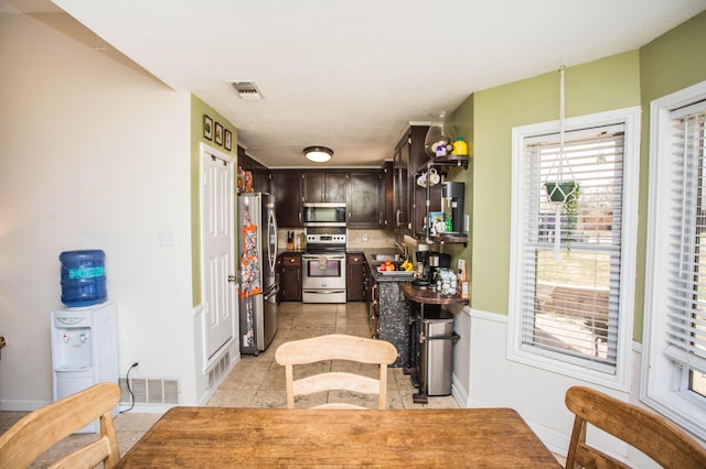 kitchen with tasteful backsplash, visible vents, dark brown cabinets, and appliances with stainless steel finishes