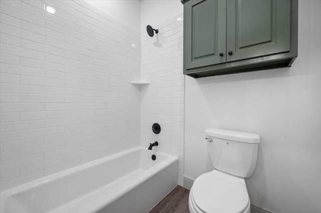 bathroom with hardwood / wood-style flooring, toilet, and tiled shower / bath combo