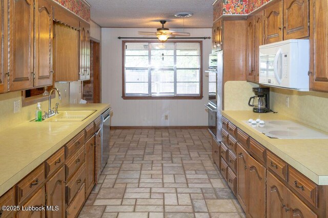 303 Comanche Trl, Tulia, TX 79088 - kitchen featuring white appliances, light countertops, brown cabinets, a ceiling fan, and a textured ceiling