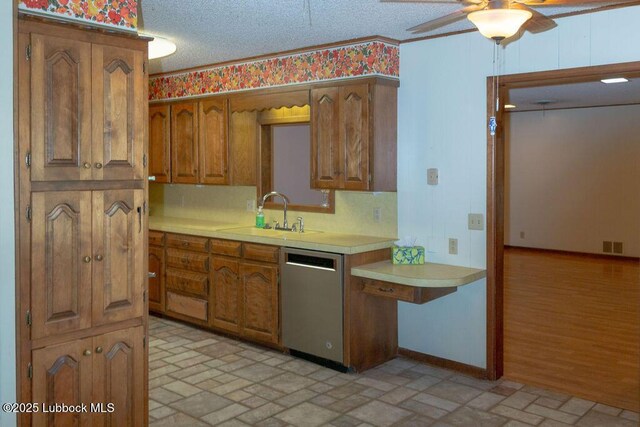 303 Comanche Trl, Tulia, TX 79088 - kitchen featuring stainless steel dishwasher, light countertops, brick patterned flooring, brown cabinets, and a ceiling fan