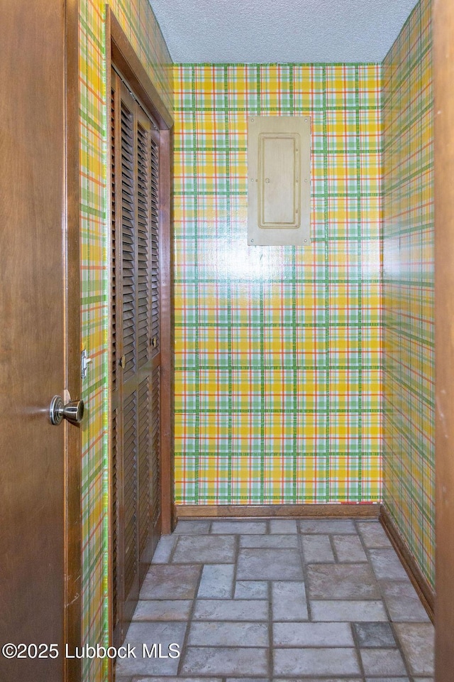 303 Comanche Trl, Tulia, TX 79088 - bathroom with wallpapered walls, electric panel, and a textured ceiling