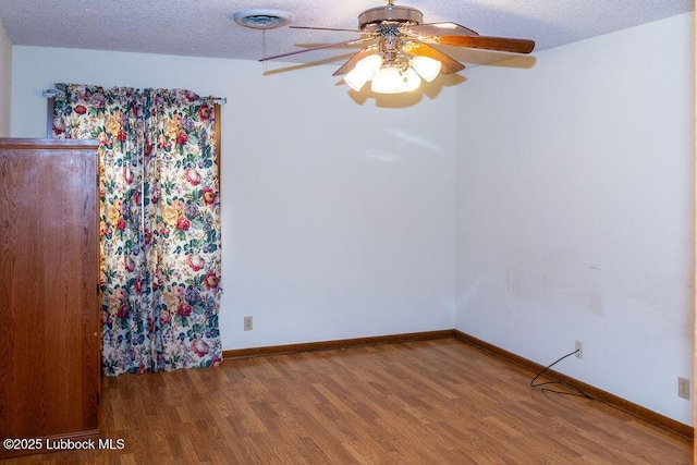 303 Comanche Trl, Tulia, TX 79088 - unfurnished room featuring wood finished floors, ceiling fan, and a textured ceiling