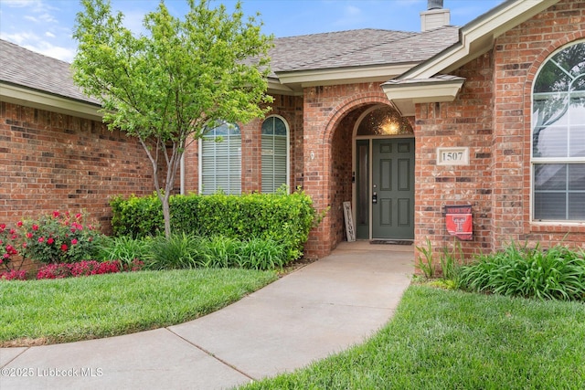 1507 Nottingham Ave, Wolfforth, TX 79382 - entrance to property featuring brick siding, a shingled roof, and a chimney